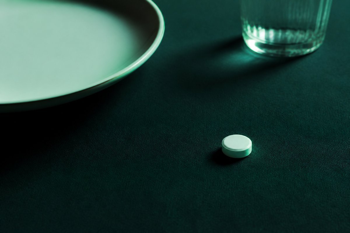 Forest-green still life: empty plate pushed aside, tablet on the forest cloth