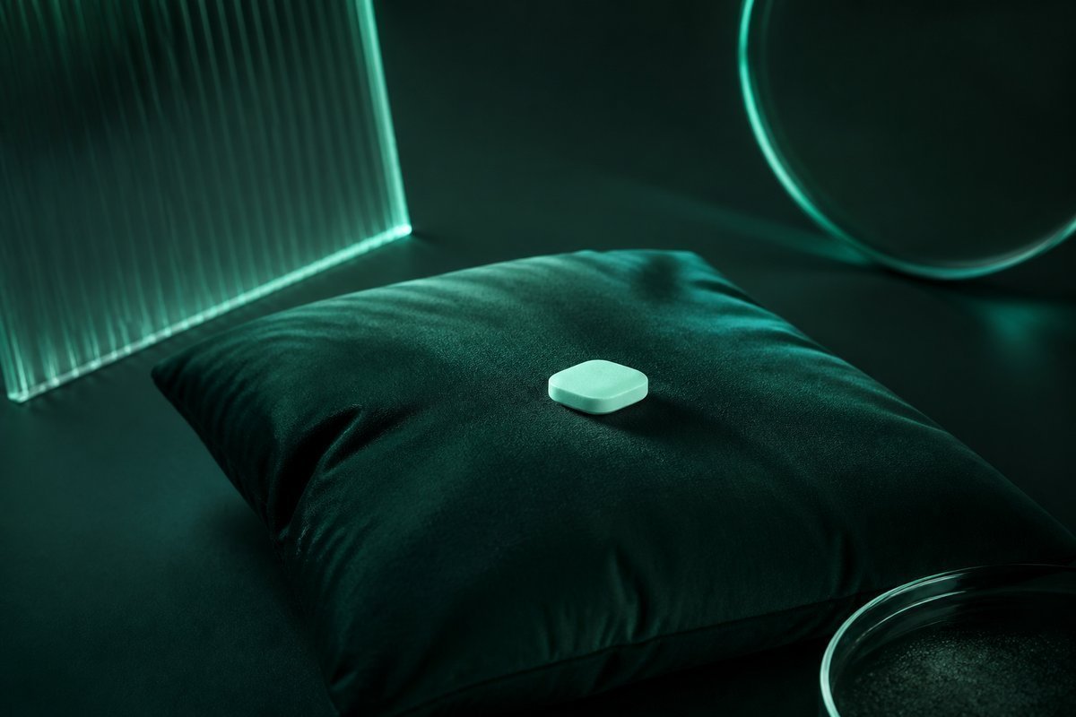 Forest-green still life: soft pillow and a small tablet