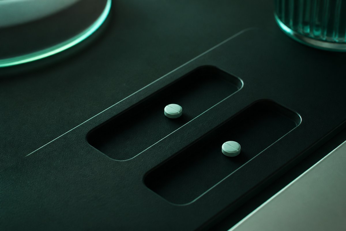 Forest-green still life: two slots, tiny tablets