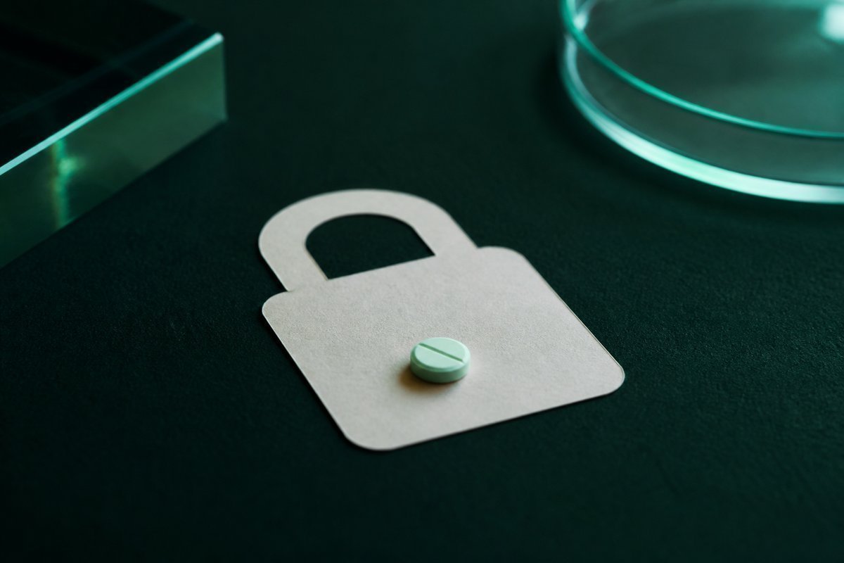Forest-green still life: single 10 mg tablet on a lock-shaped card