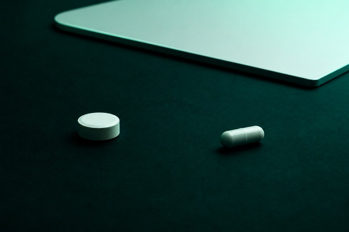 Forest-green still life: antacid roll far from a capsule